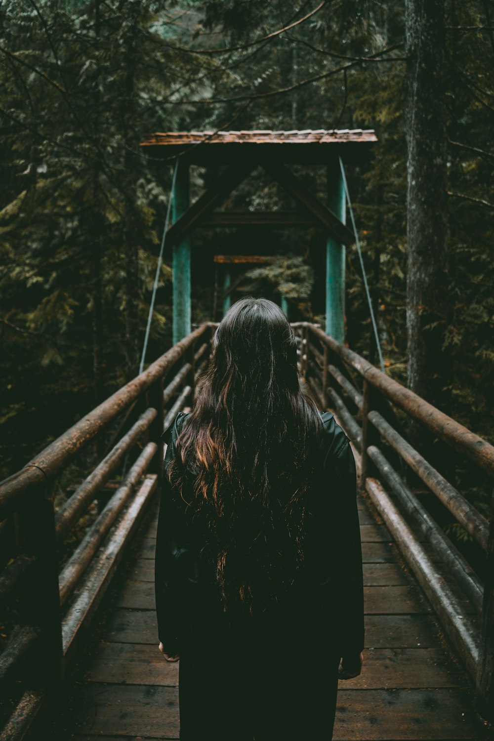 woman standing on brown bridge