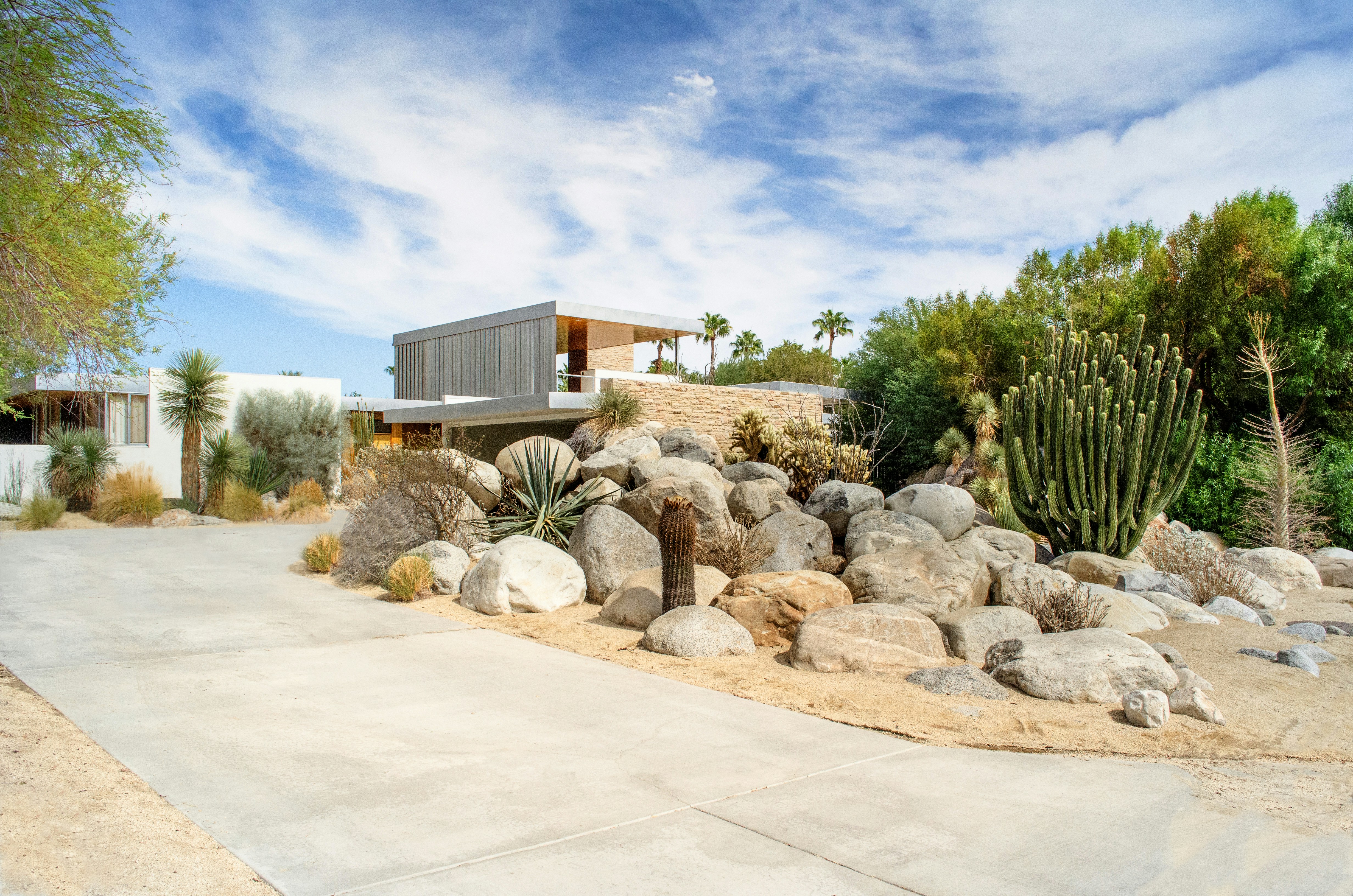Modern luxury home exterior with desert landscape at sunset