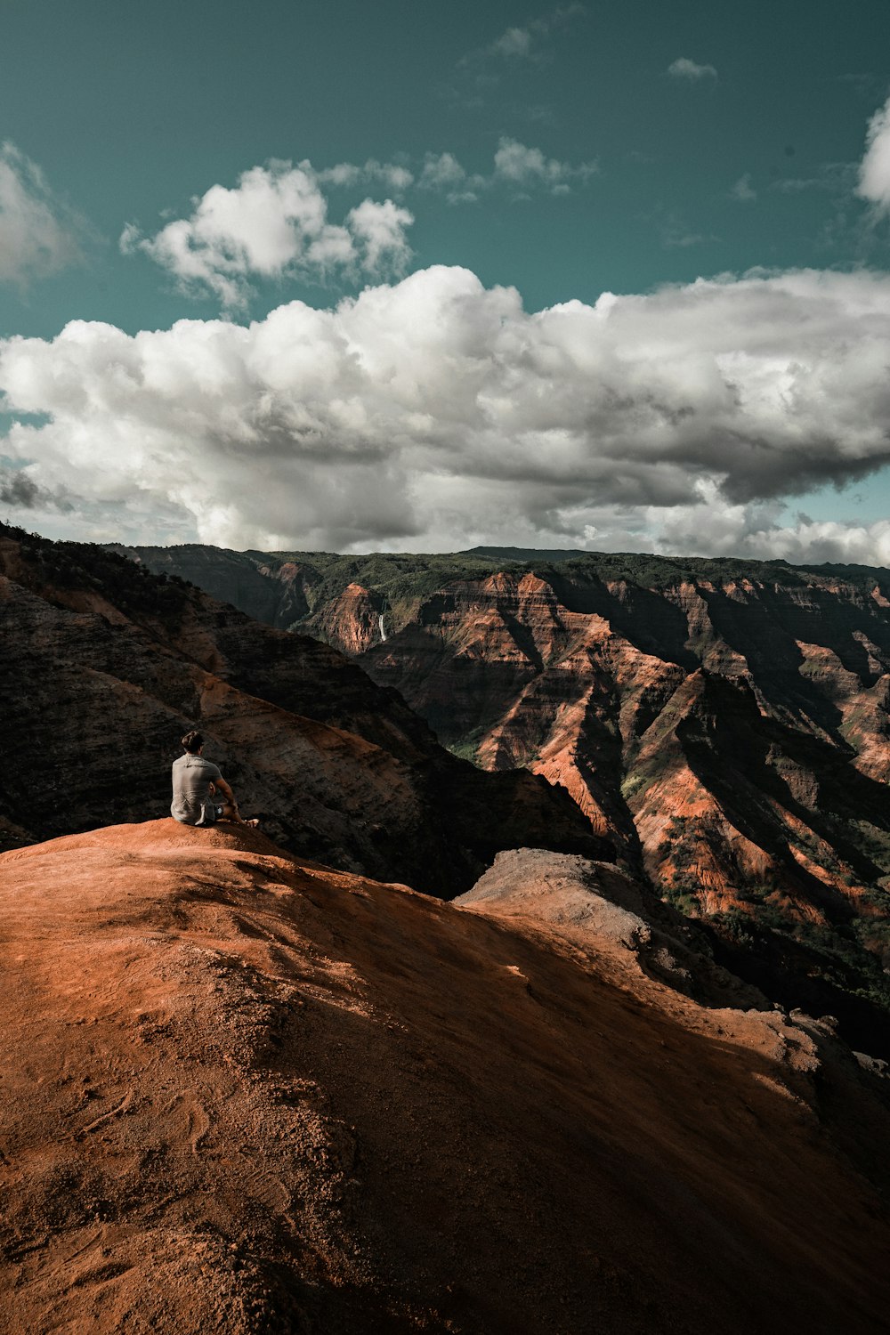 personne assise sur la falaise de montagne