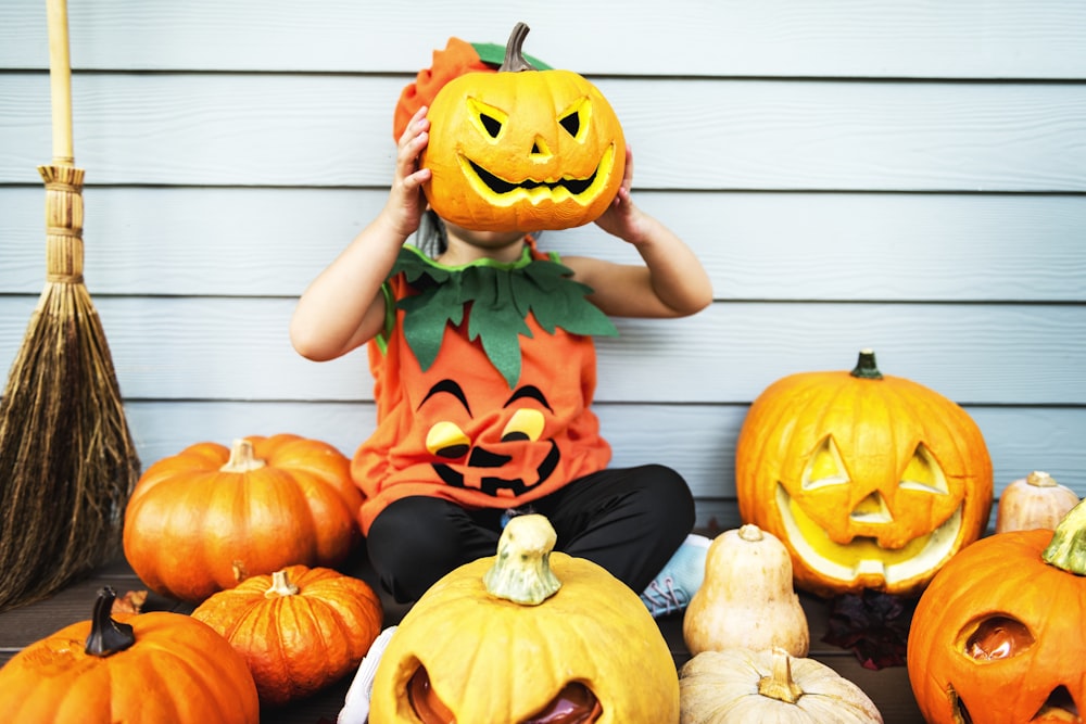 baby holding pumpkin