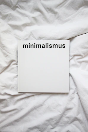 Close-up of a minimalist white book cover with delicate typography on a wooden table