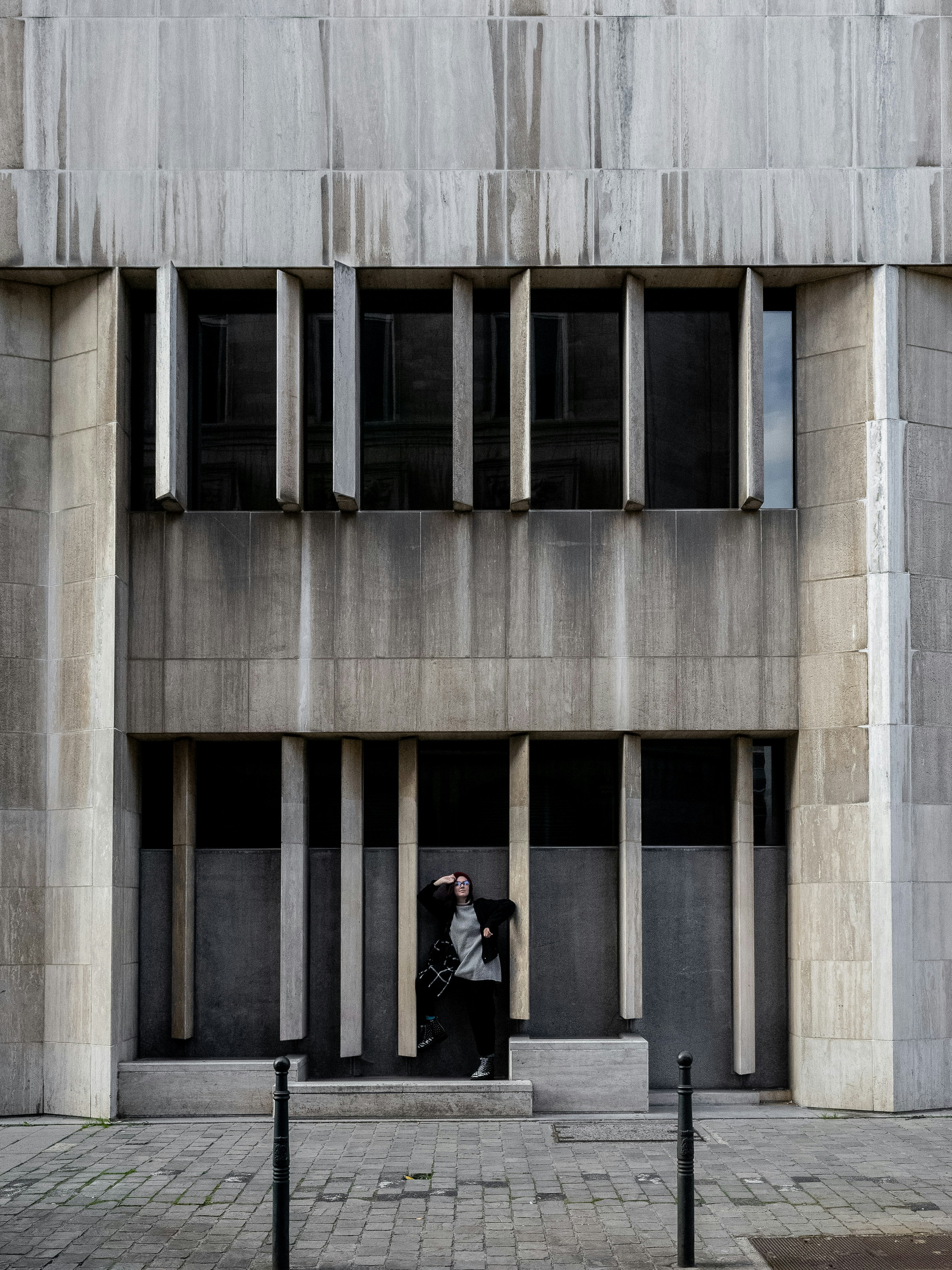 person standing in front of gray concrete building