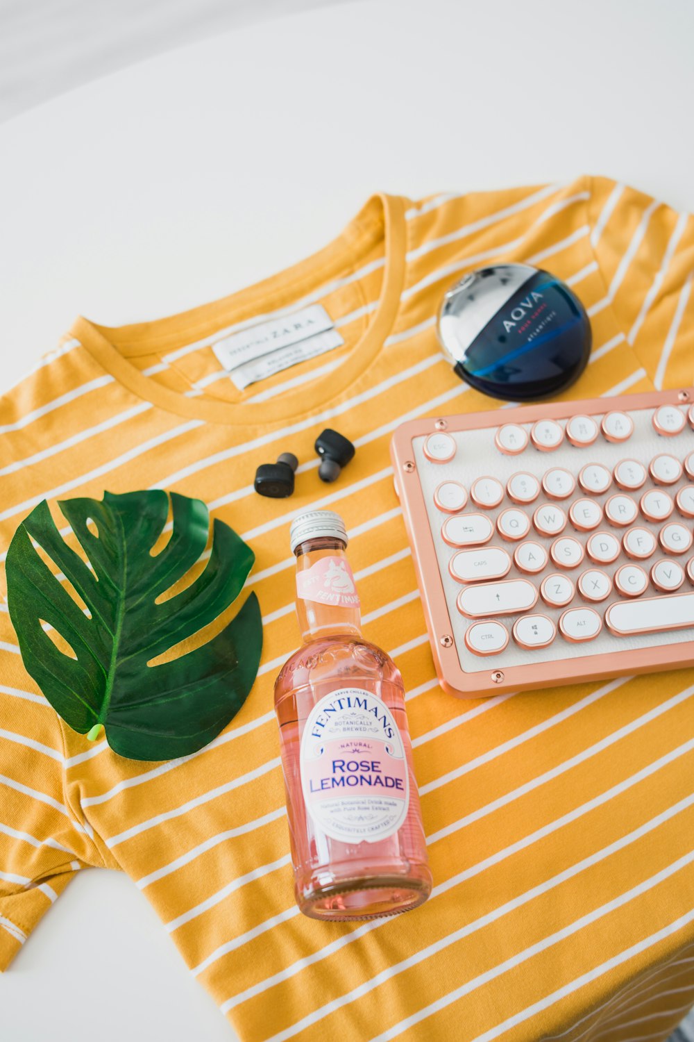 bottle and keyboard on striped crew-neck shirt