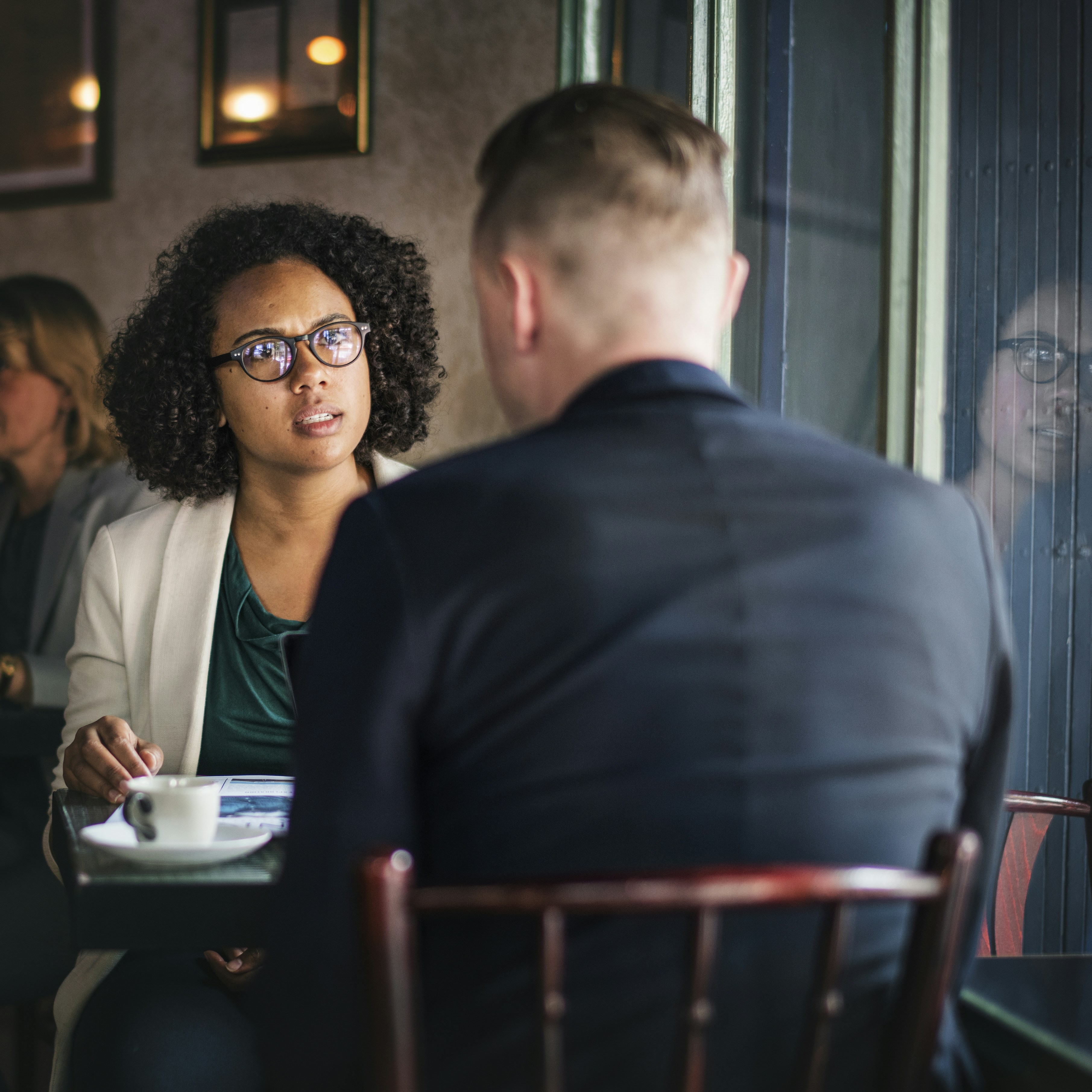 woman in front of man seating on brown chair