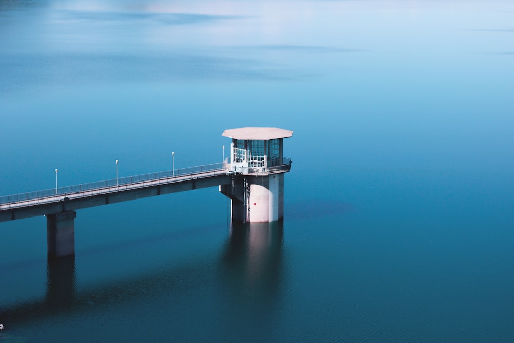 grey dock with tower on body of water during day