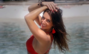 A smiling woman enjoying a sunny beach day, radiating confidence and health