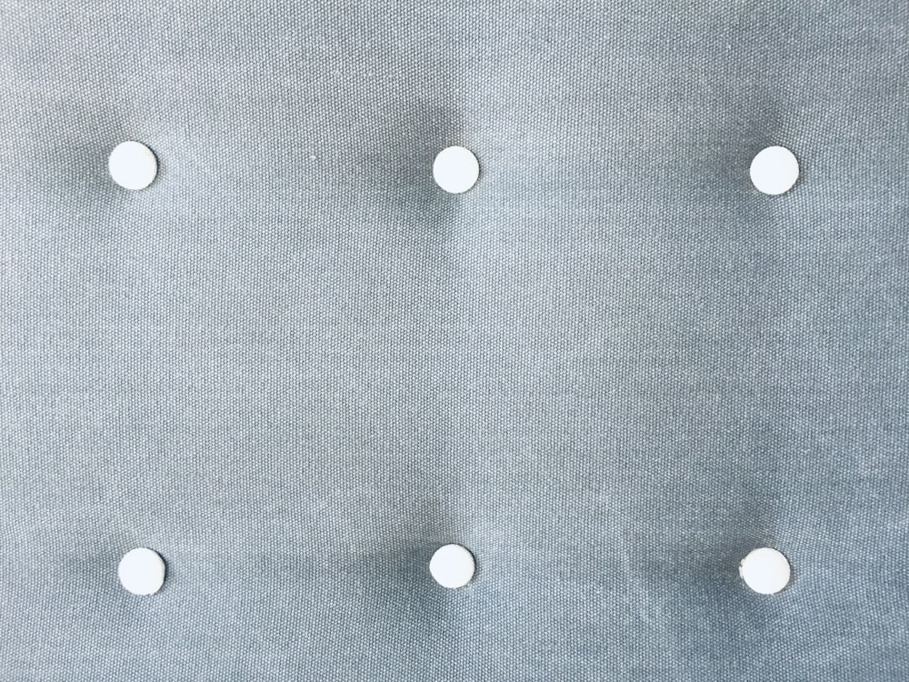 a close up of a metal plate with white buttons