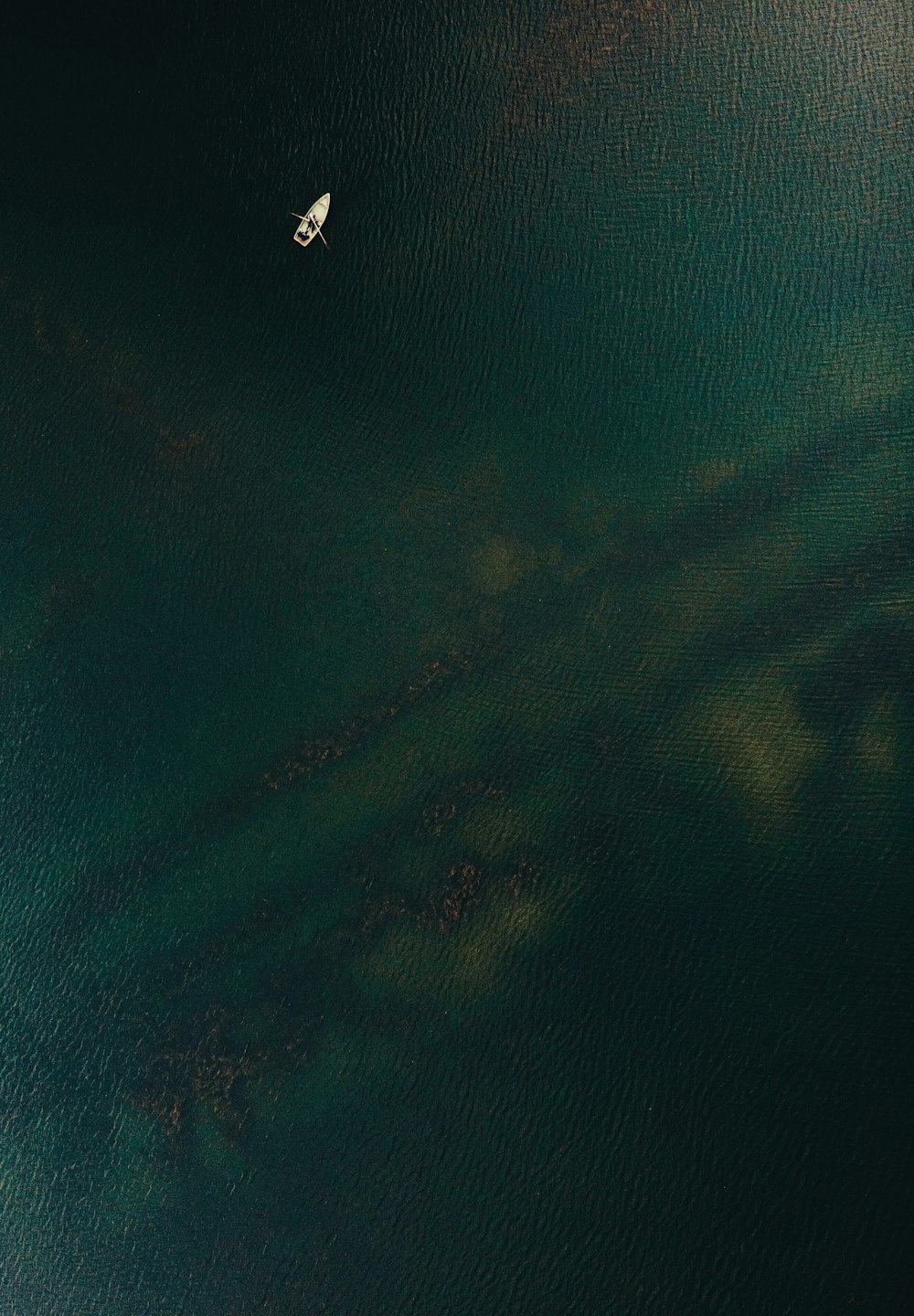 a small boat floating on top of a large body of water