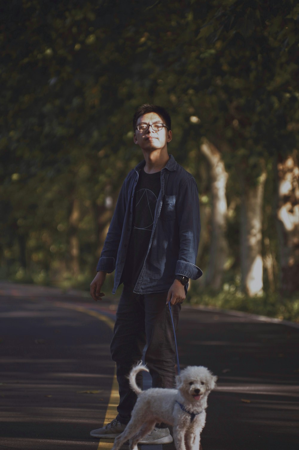 man in black zip up jacket standing on road during daytime