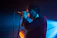 Close-up of Jai Reign passionately singing into a vintage microphone under moody purple lighting.