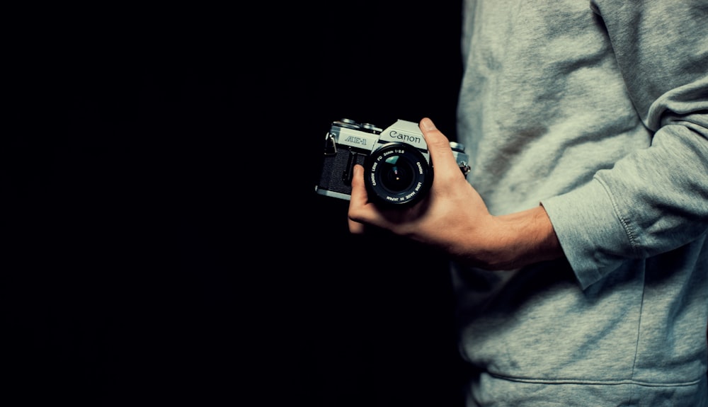 person holding black and gray camera