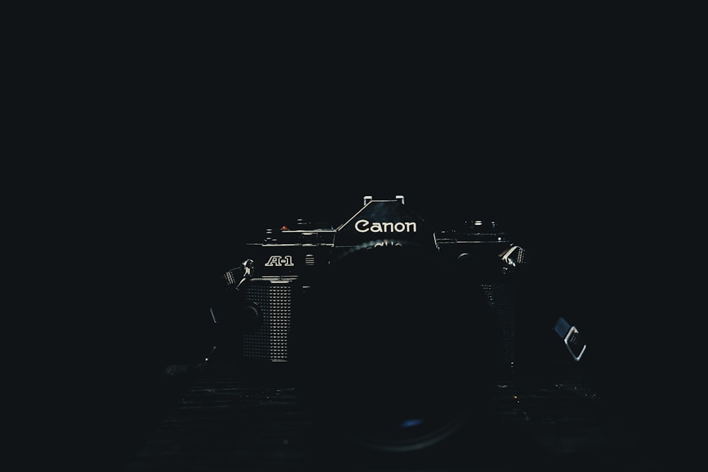 black Canon DSLR camera with black background