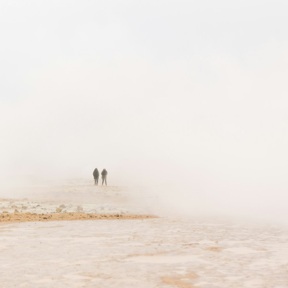 silhouette of two persons on sand