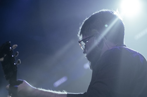 A musician playing guitar on a stage.
