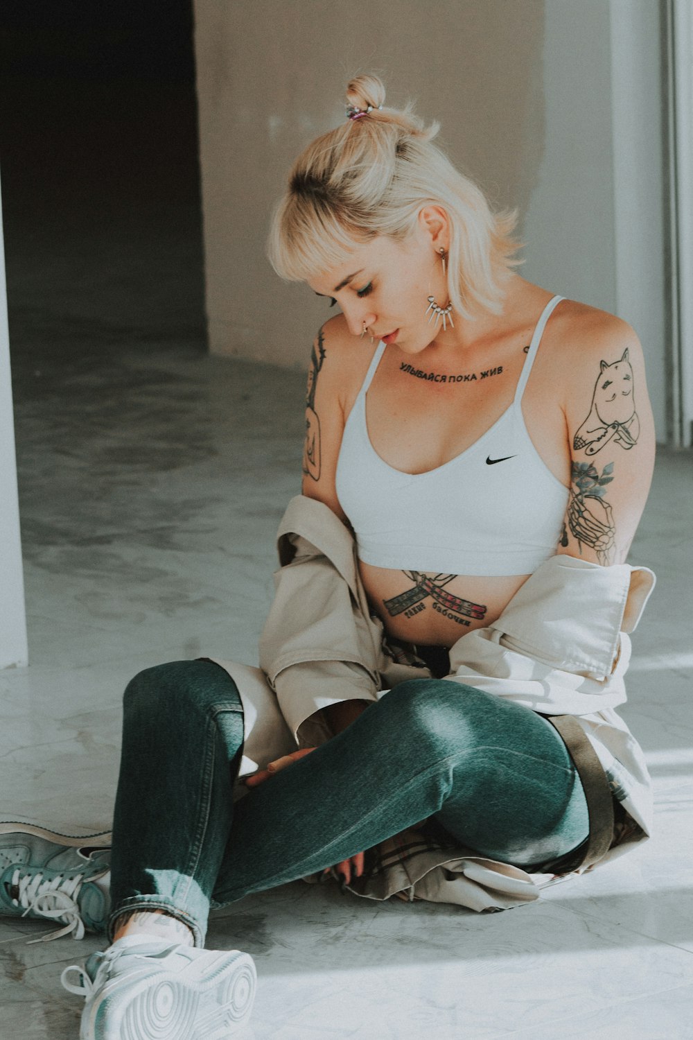 woman wearing white Nike sports bra sitting on concrete floor