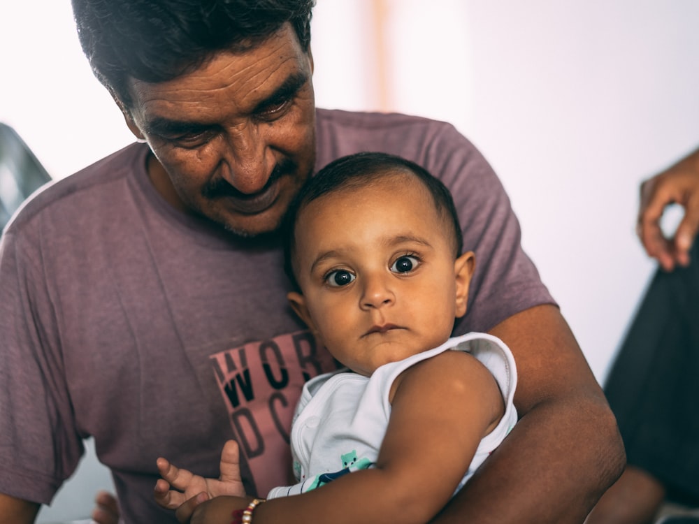 man carrying baby on his lap