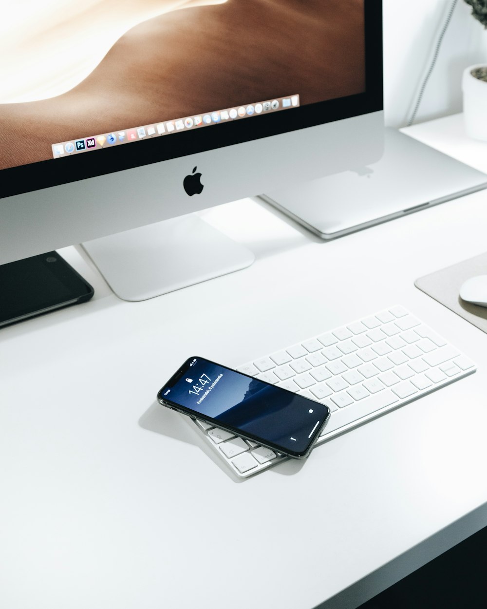 black smartphone on white Apple Magic keyboard