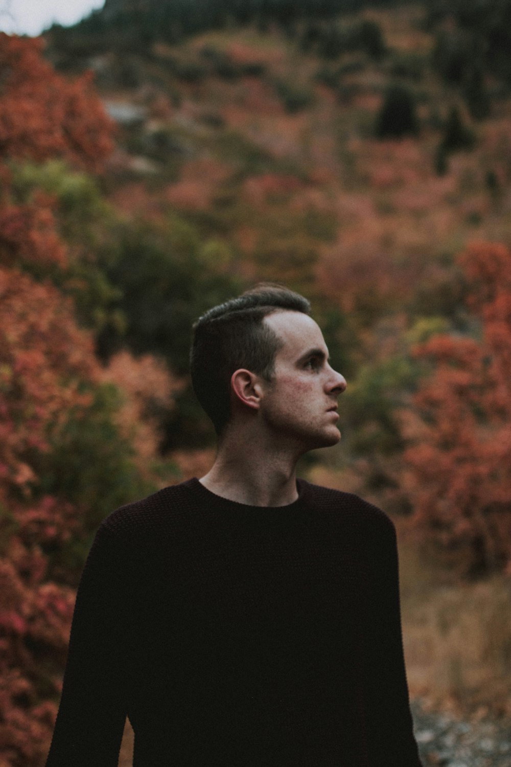 man standing outdoor near trees during daytime