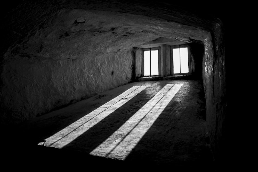 grayscale photography of tunnel with windows