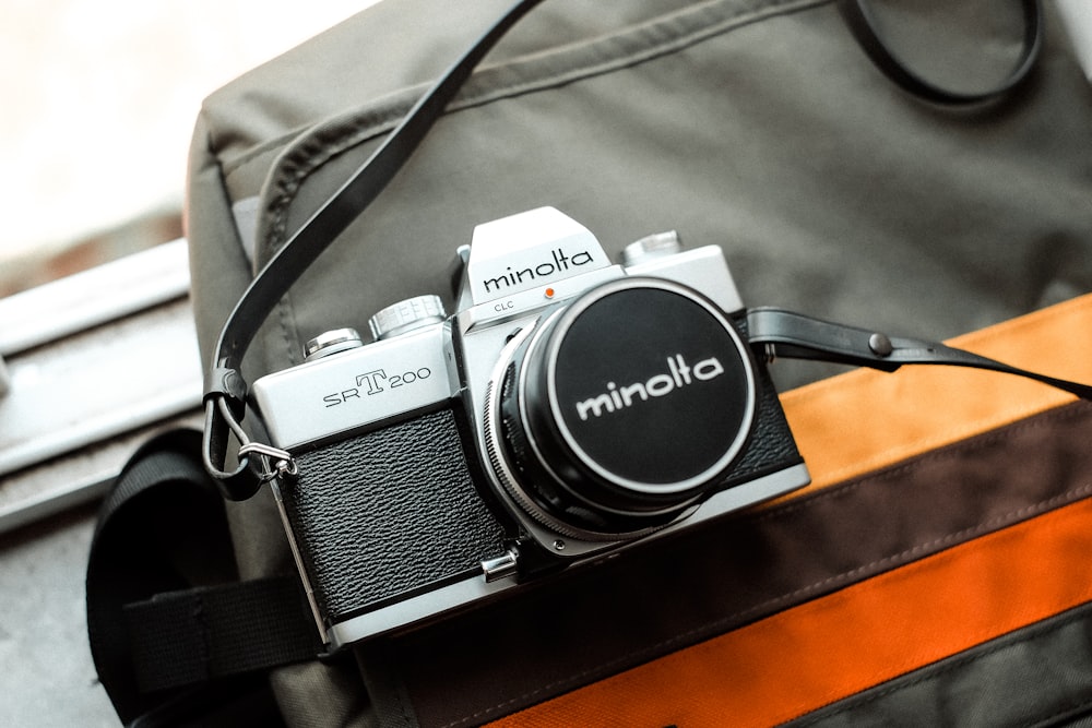 silver and black Minolta SLR camera on gray bag