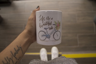 person holding white mug