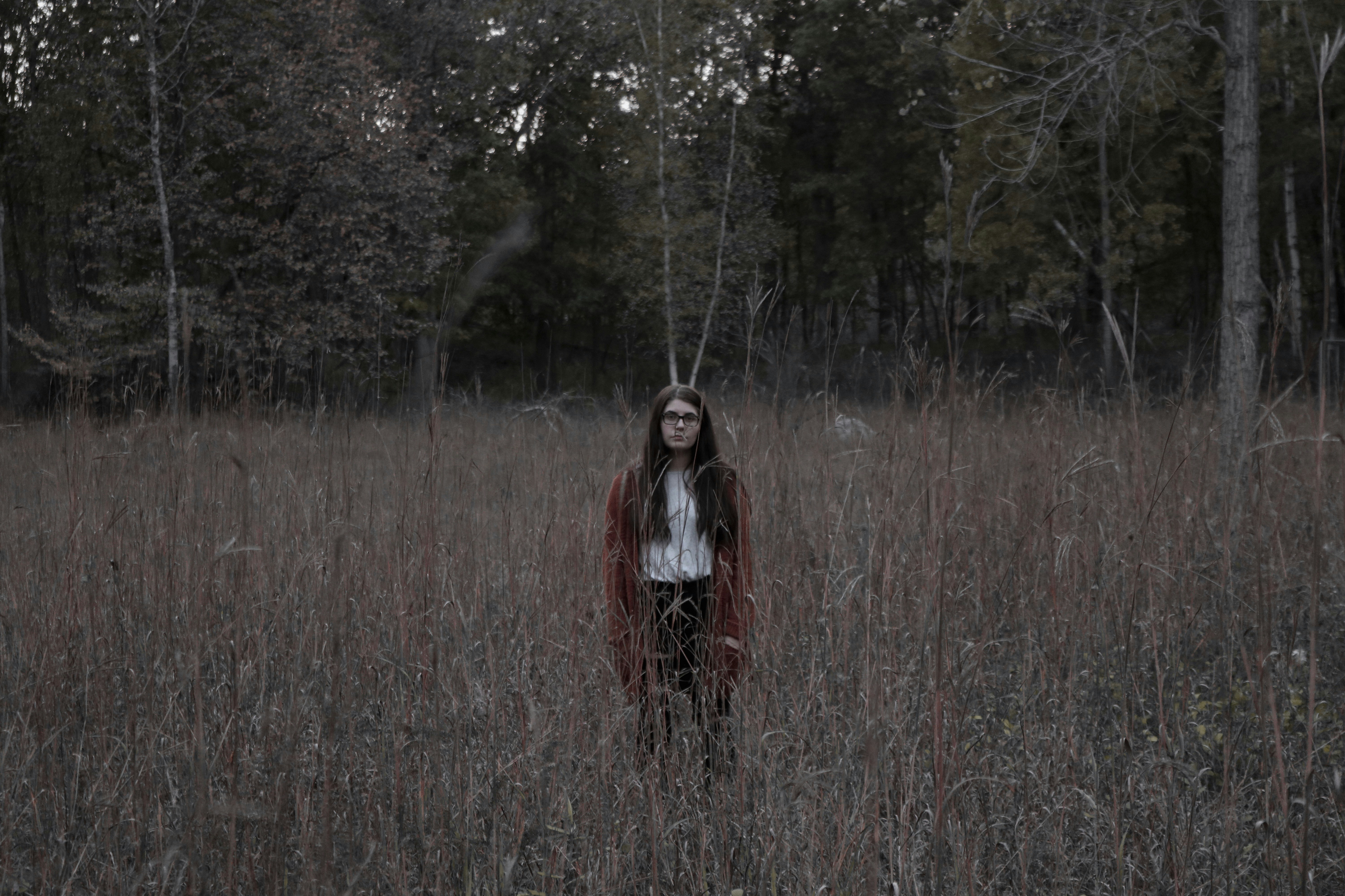 woman standing on the ground surrounded by grass