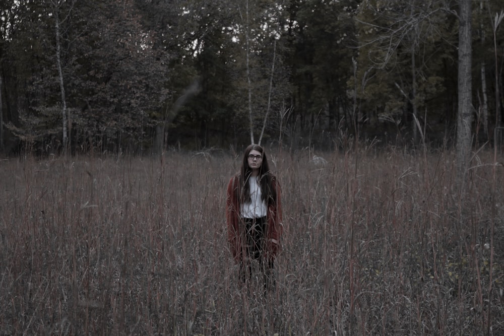 woman standing on the ground surrounded by grass