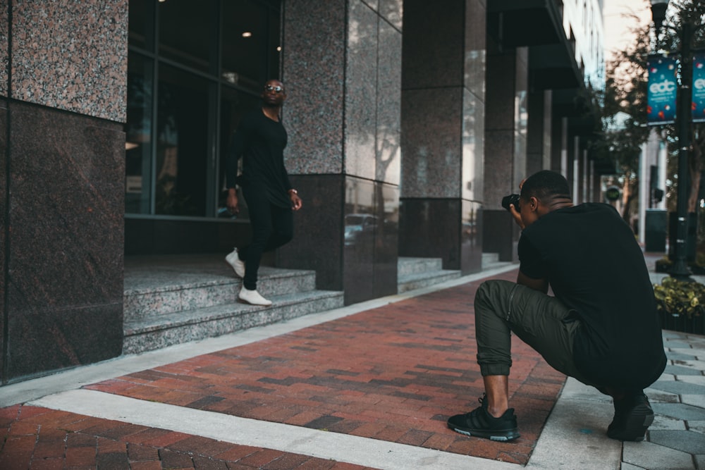 man taking photo of man walking downstair