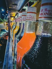 A colorful array of syrups in glass bottles.