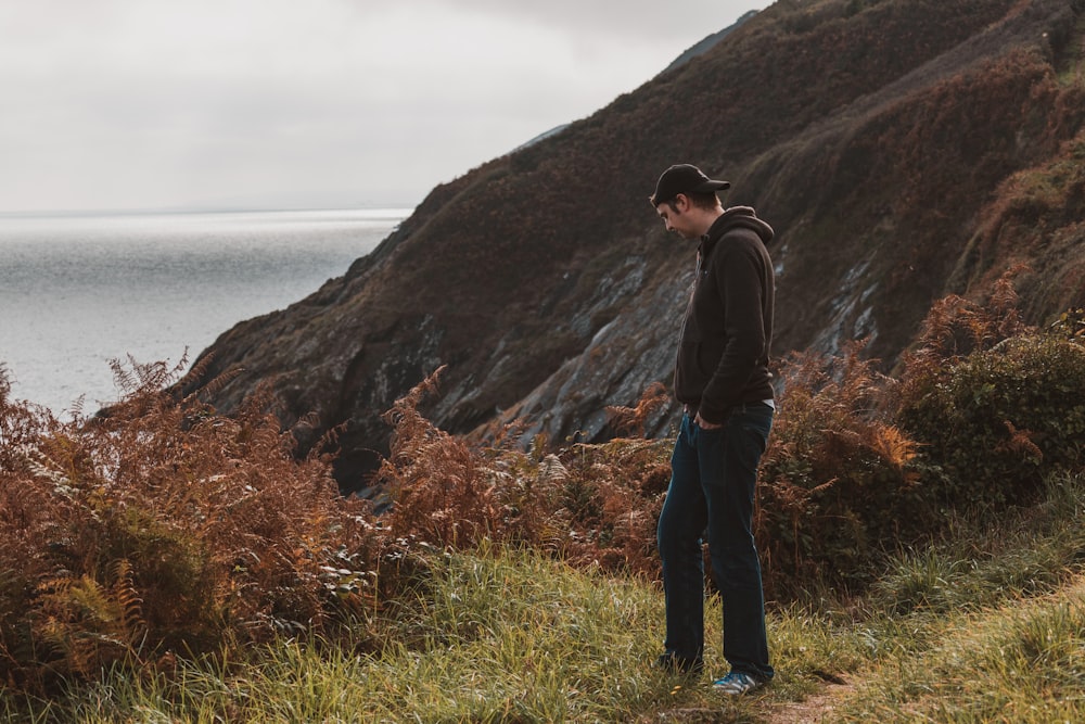 man standing near mountain cliff