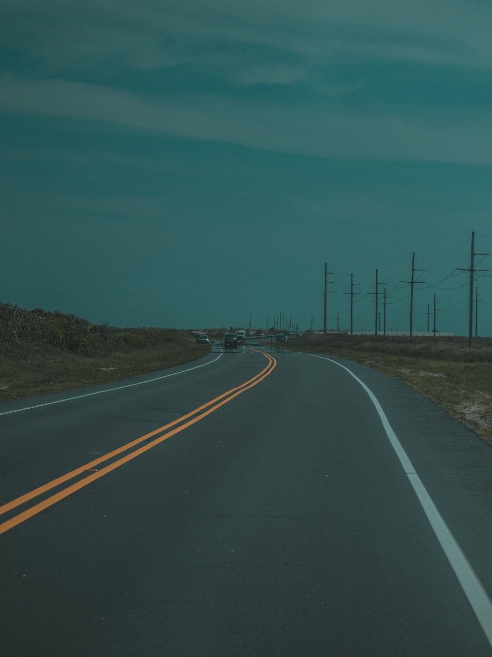 low light photography of asphalt road under cloudy sky