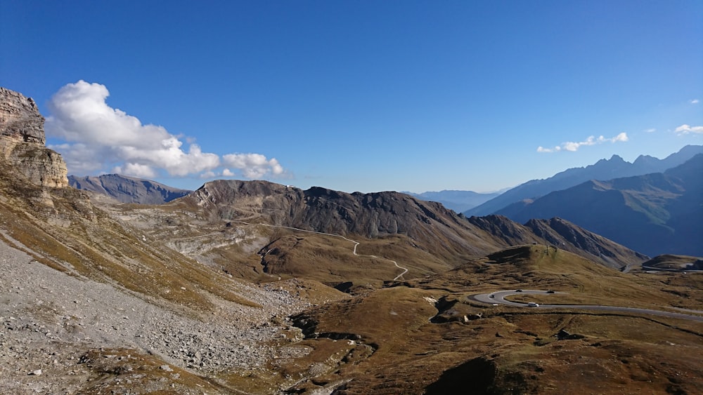 landscape photography mountain with gray road under blue sky during daytime