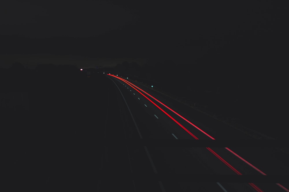 time-lapse photography of vehicle passing road during night