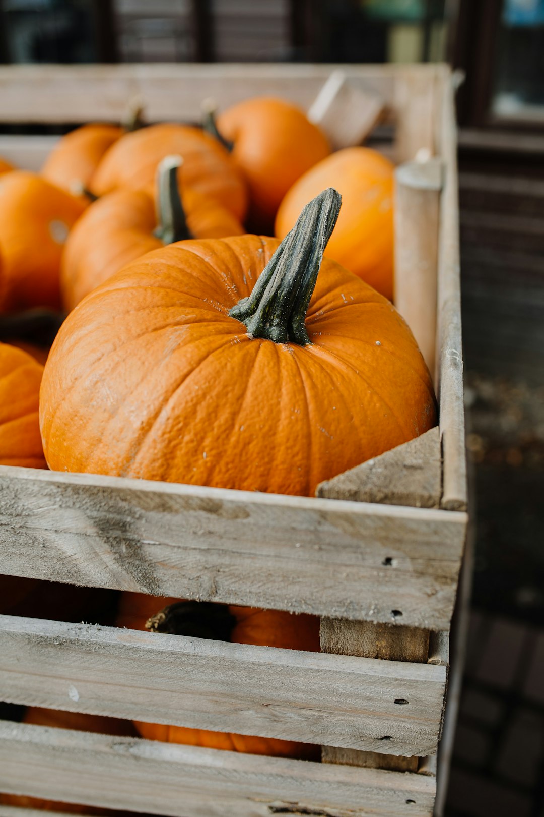 orange pumpkins inside brown wooden crate