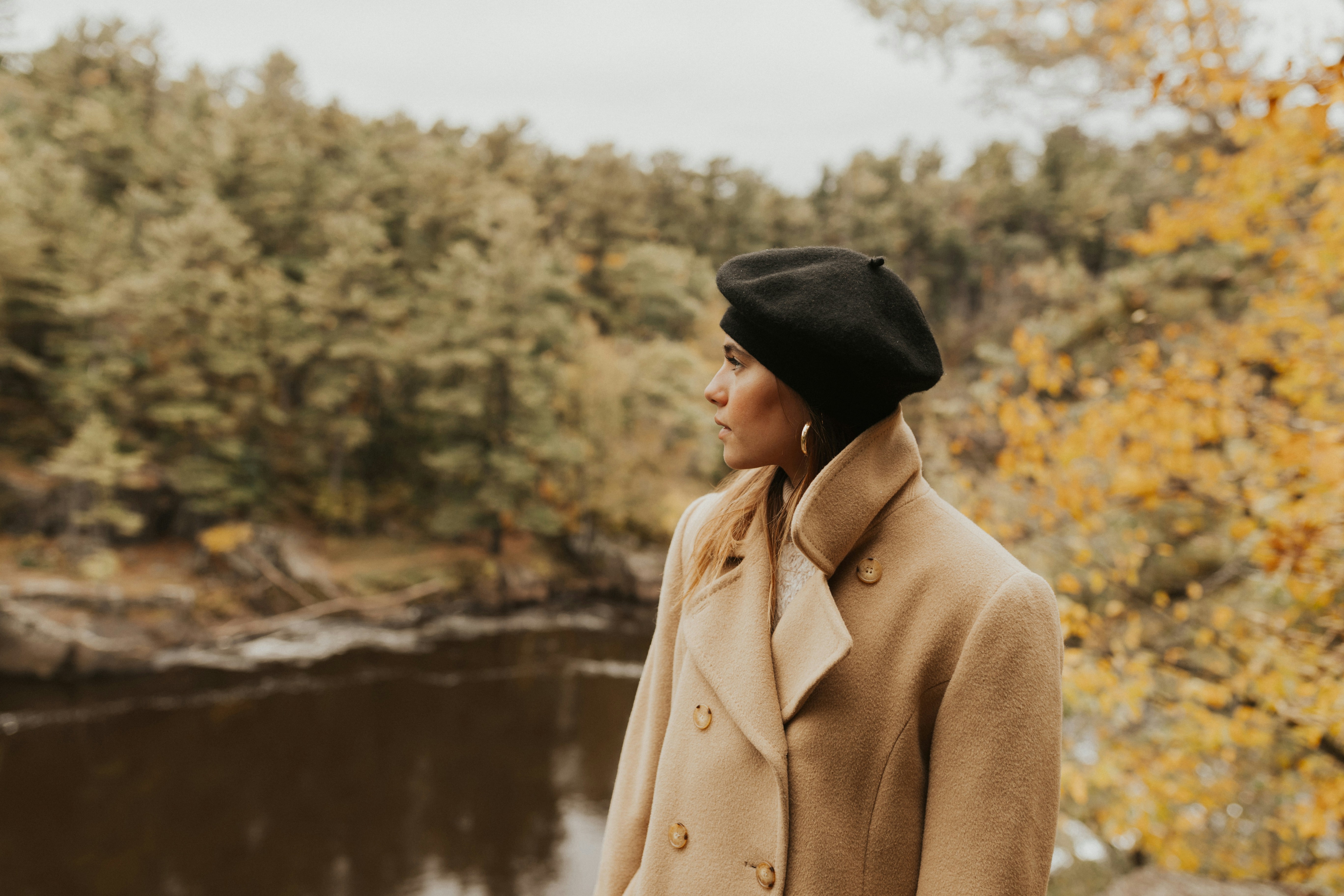 woman standing looking her right side near lake