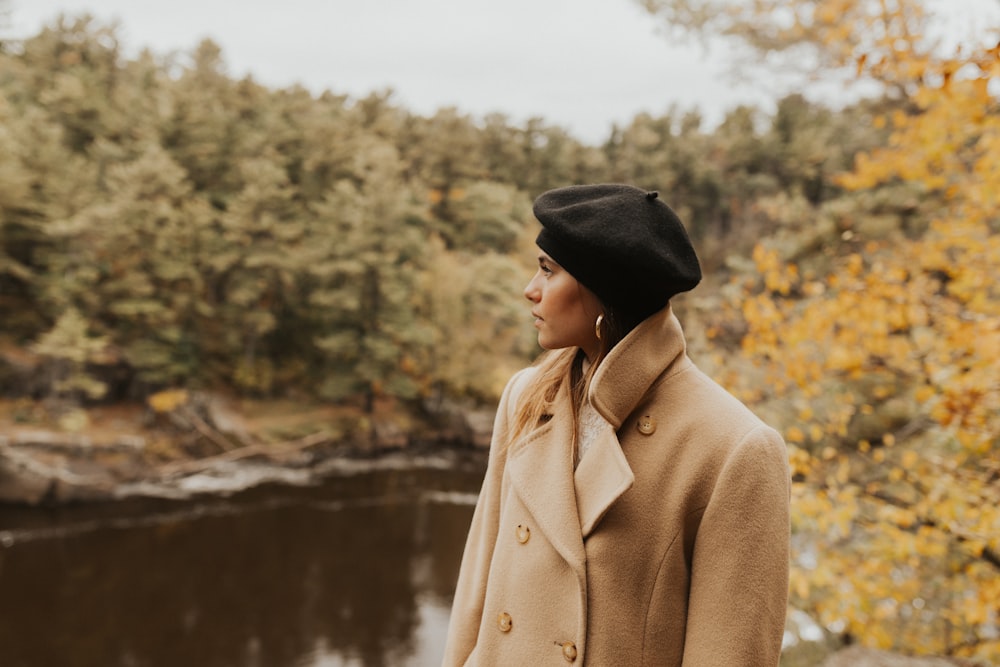 woman standing looking her right side near lake