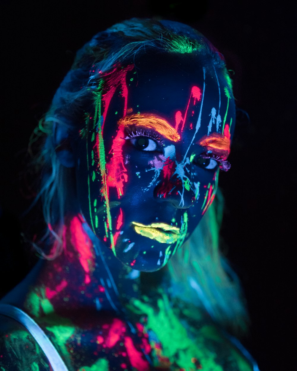 femme avec lueur dans la peinture corporelle sombre