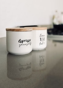two white ceramic container on gray marble surface
