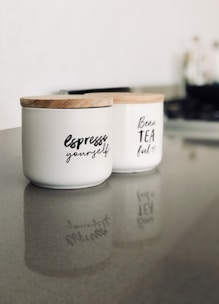 two white ceramic container on gray marble surface