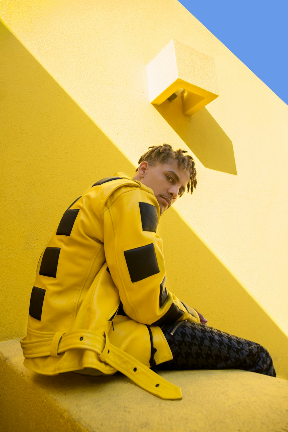 man wearing yellow and black jacket sitting inside room