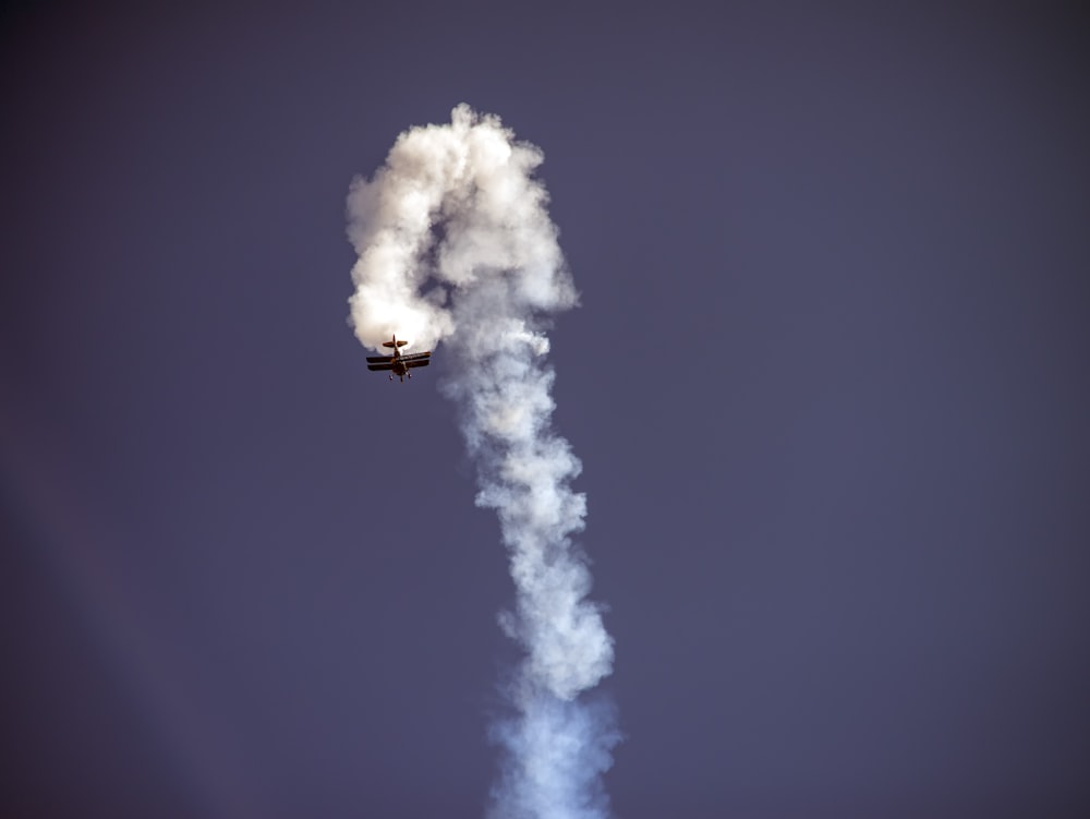 black plane with white smoke