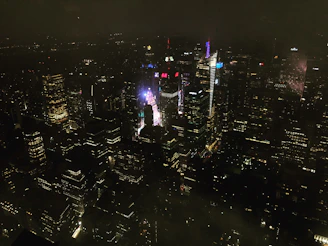 A vibrant cityscape at night illuminated by digital billboards and neon lights