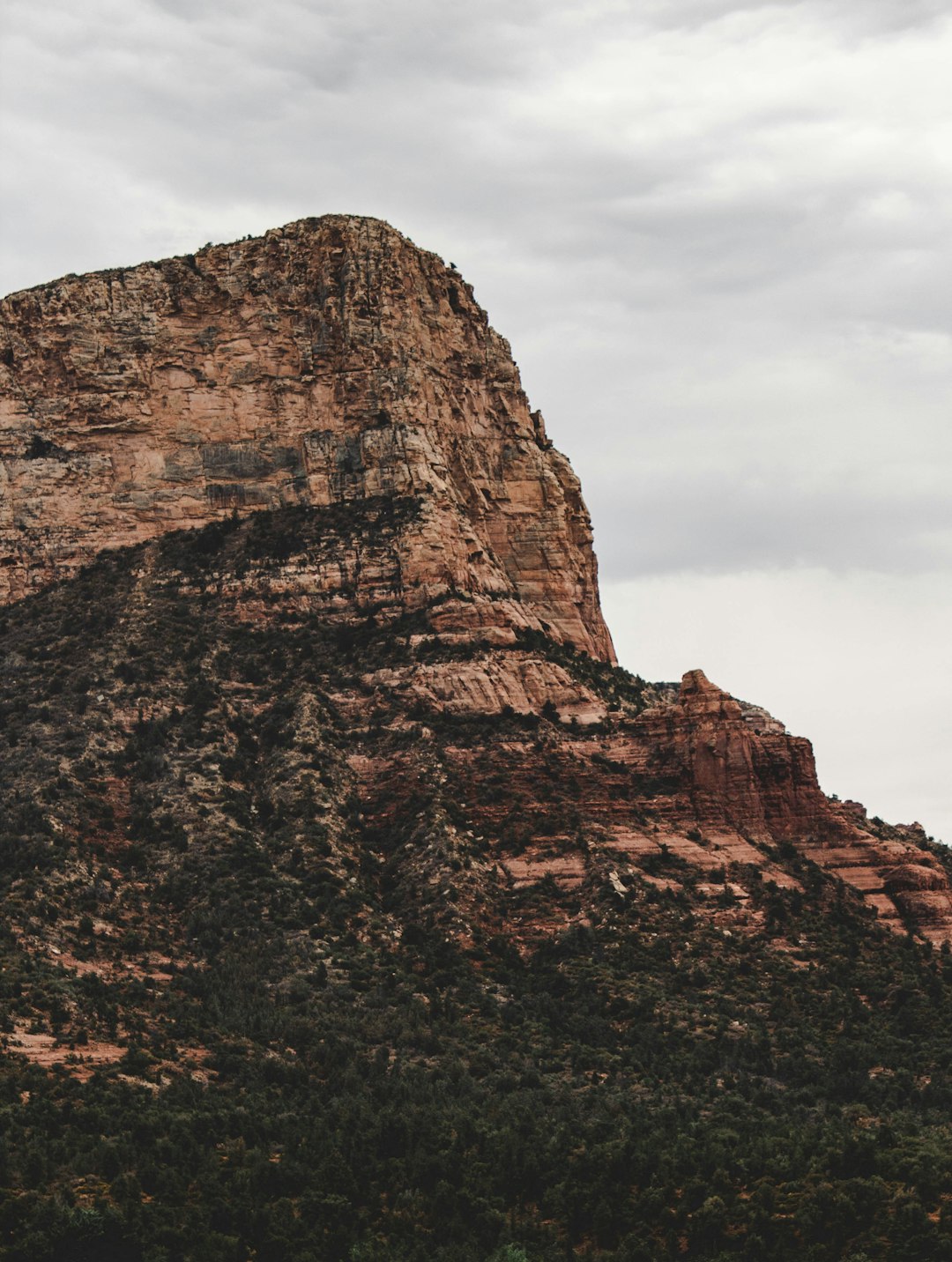 brown stone hill under white cloudy sky