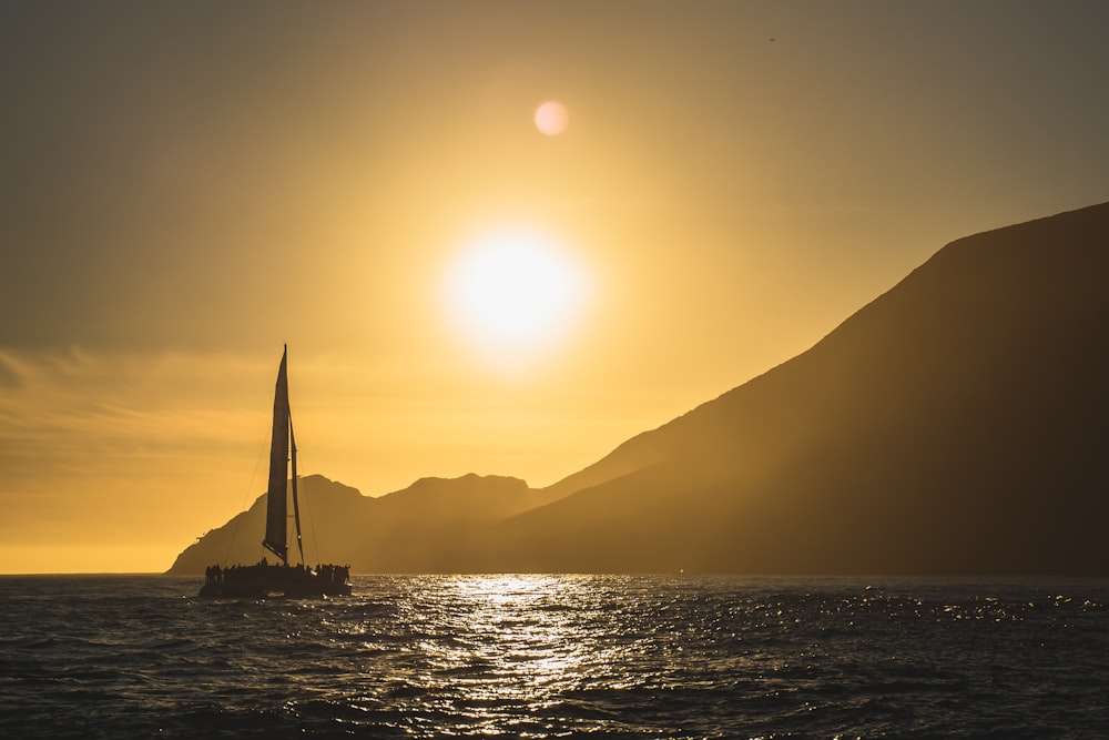 ヨットで海に沈む夕日の風景写真