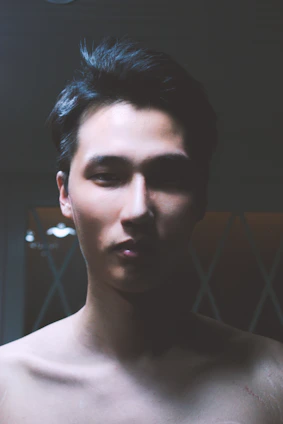 Portrait of Humbert Acosta in a modern, minimalistic setting with cosmic symbols softly glowing around him.