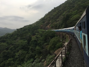 A peaceful mountain train winding through lush green valleys under a clear sky