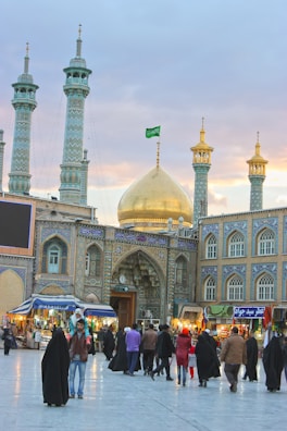 Group of travelers smiling in front of the grand mosque entrance.