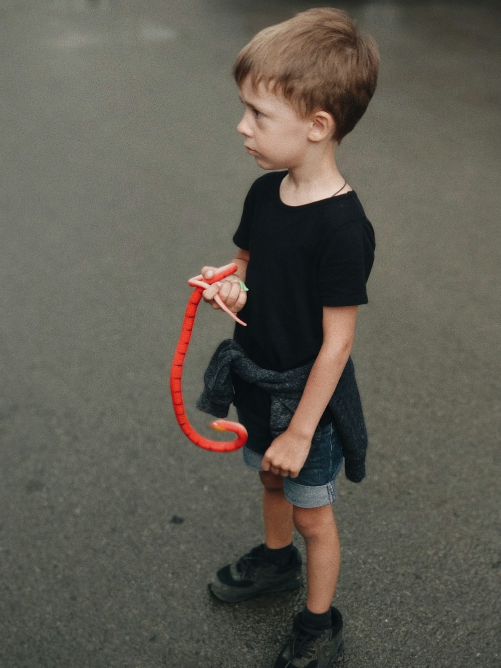 garçon tenant un jouet serpent rouge