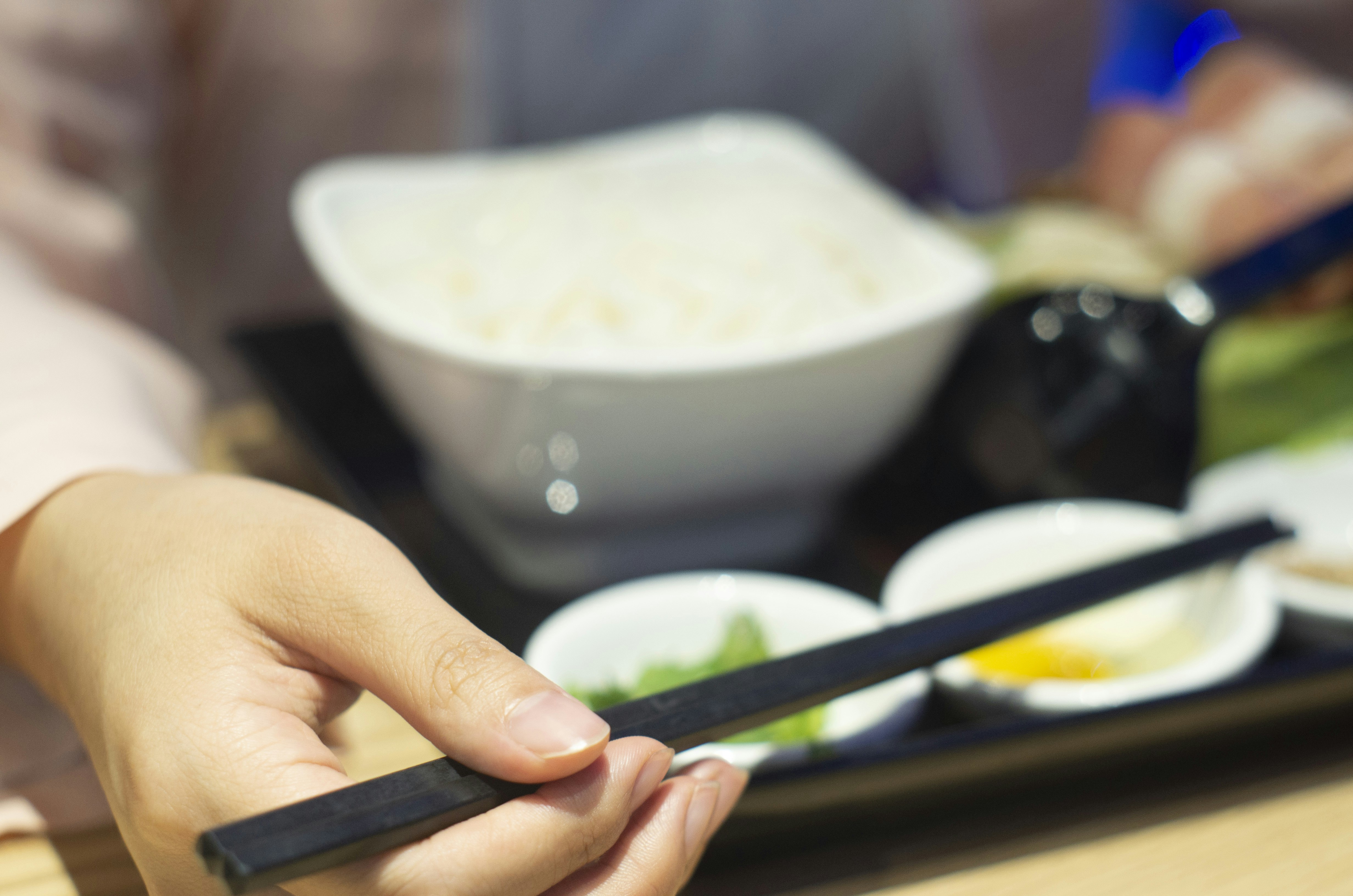 person holding pair of chopsticks