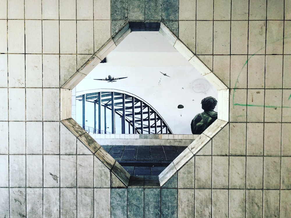 mirror displaying planes and concrete bridge